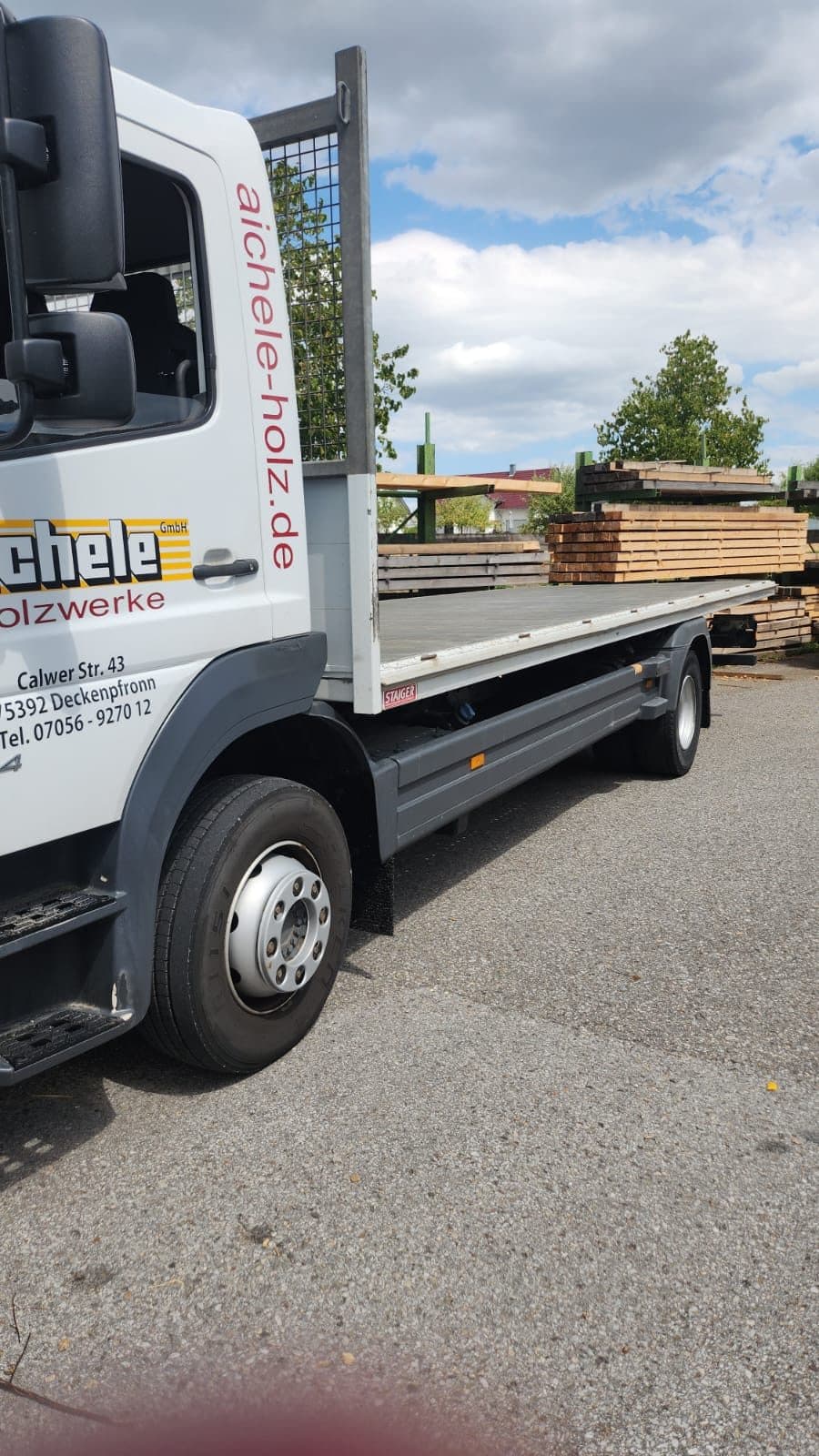 Pritschen-Lkw mit Firmenbeschriftung auf dem Hof