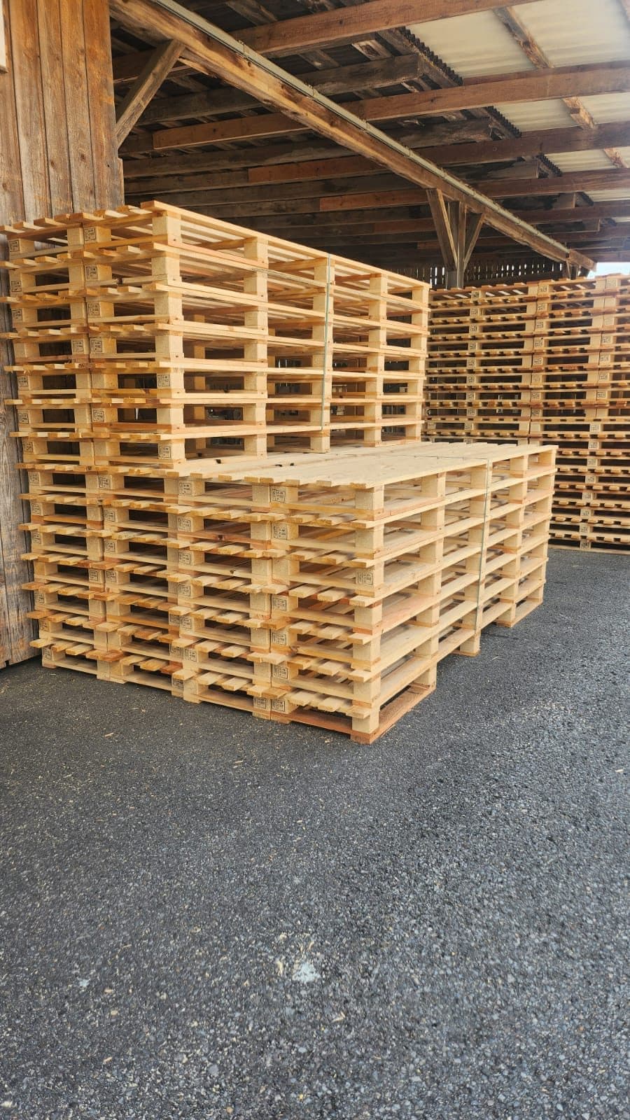Stapel neuer Paletten im überdachten Lager